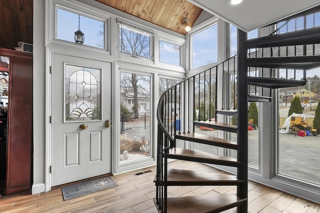 foyer with wooden ceiling, stairway, visible vents, and light wood finished floors