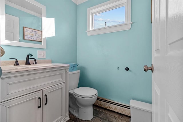 bathroom with vanity, toilet, and baseboard heating