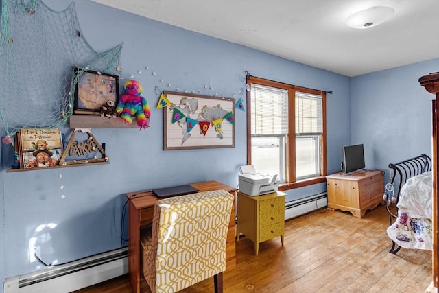 bedroom featuring hardwood / wood-style floors and a baseboard heating unit