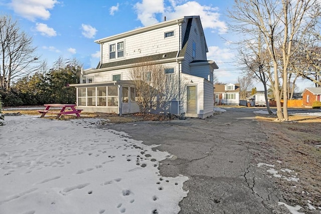 rear view of house featuring a sunroom