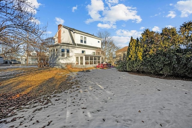 back of property with a sunroom