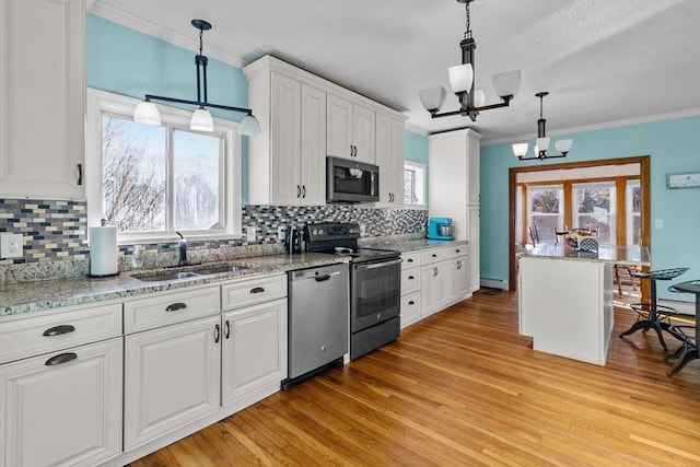 kitchen featuring white cabinetry, stainless steel appliances, decorative light fixtures, and sink