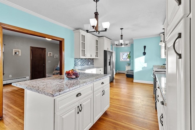 kitchen with tasteful backsplash, a chandelier, appliances with stainless steel finishes, pendant lighting, and white cabinets