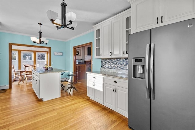 kitchen with a notable chandelier, hanging light fixtures, white cabinets, and stainless steel fridge with ice dispenser