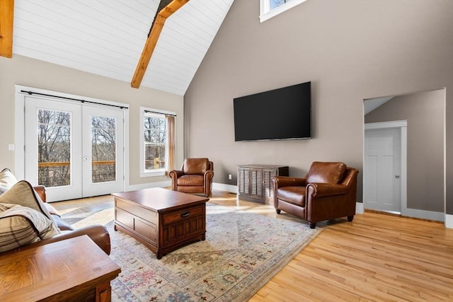 living room featuring beam ceiling, high vaulted ceiling, and light hardwood / wood-style flooring