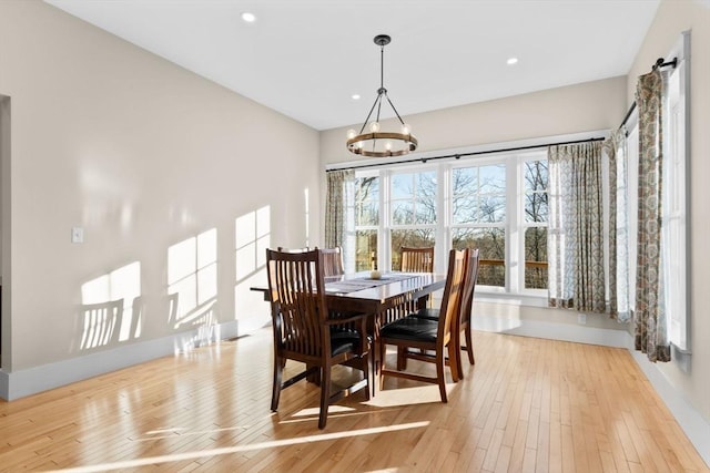 dining area with a chandelier and light hardwood / wood-style flooring