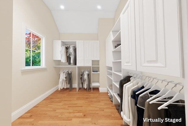 spacious closet with lofted ceiling and light wood-type flooring