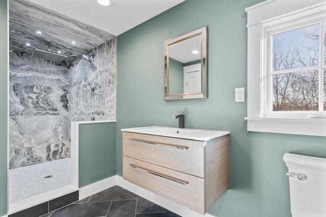 bathroom with tile patterned floors, vanity, toilet, and a shower