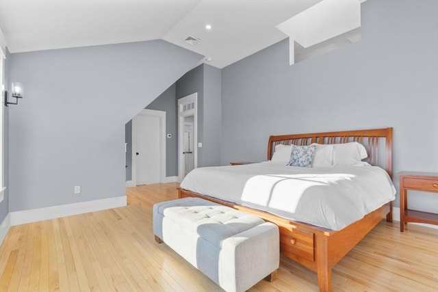 bedroom with vaulted ceiling and light hardwood / wood-style flooring