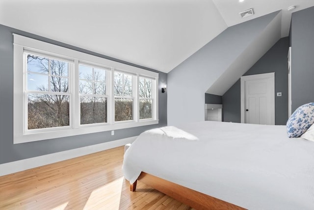 bedroom featuring hardwood / wood-style flooring and lofted ceiling