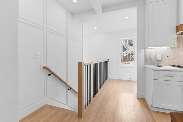 interior space with beamed ceiling and light hardwood / wood-style flooring