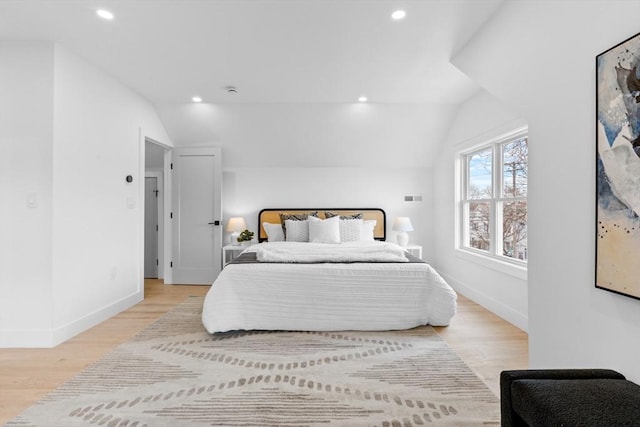 bedroom with vaulted ceiling and light hardwood / wood-style floors