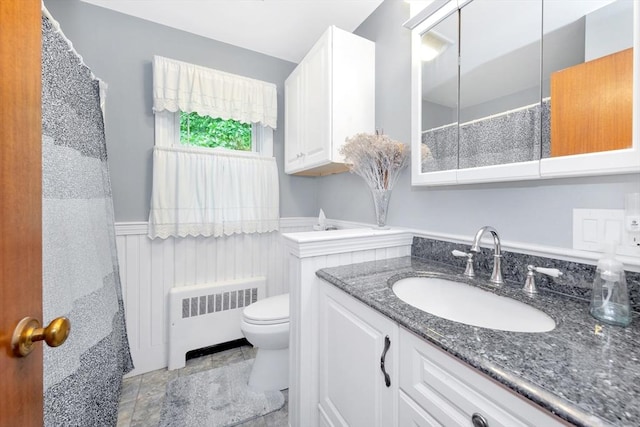 full bath with radiator, wainscoting, toilet, and vanity