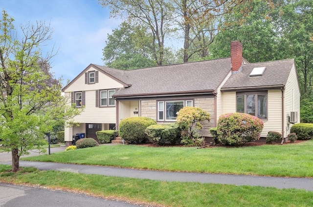 tri-level home featuring a chimney, a front yard, and a shingled roof