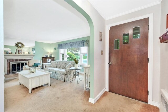 entryway featuring light colored carpet, crown molding, a fireplace, arched walkways, and radiator