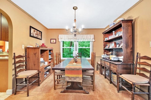 dining room with arched walkways, a chandelier, ornamental molding, and light carpet