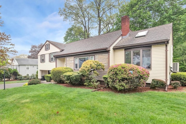 tri-level home featuring a chimney, a front lawn, a shingled roof, and central air condition unit