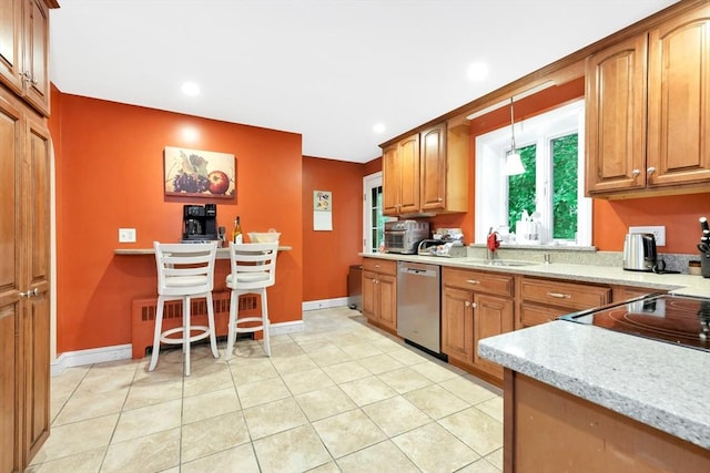 kitchen featuring stainless steel dishwasher, a sink, brown cabinets, and recessed lighting