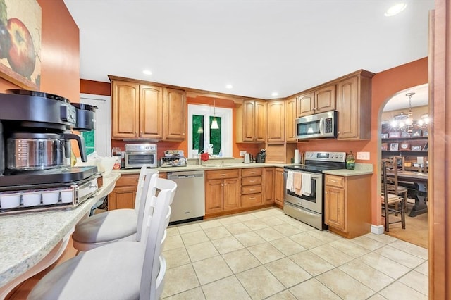 kitchen featuring appliances with stainless steel finishes, light tile patterned floors, light countertops, recessed lighting, and a sink