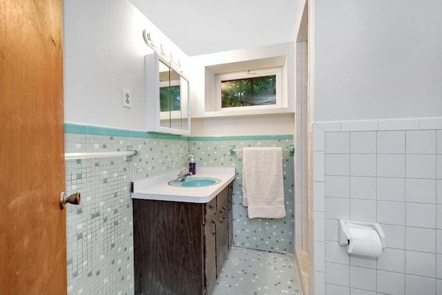 full bathroom with tile walls, wainscoting, vanity, and tile patterned flooring