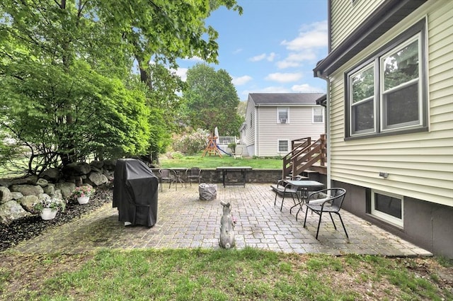 view of patio featuring a playground and area for grilling