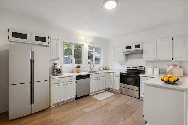 kitchen with white cabinetry, stainless steel appliances, sink, and light wood-type flooring