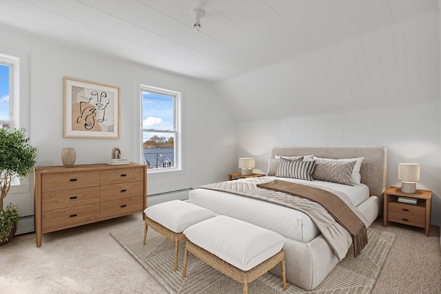 bedroom featuring vaulted ceiling, a baseboard heating unit, and light carpet