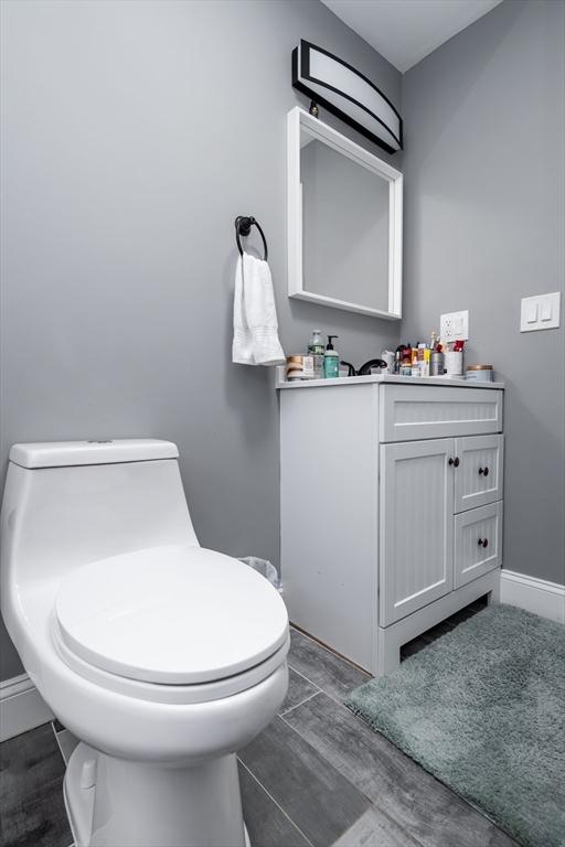 bathroom with hardwood / wood-style flooring, vanity, and toilet