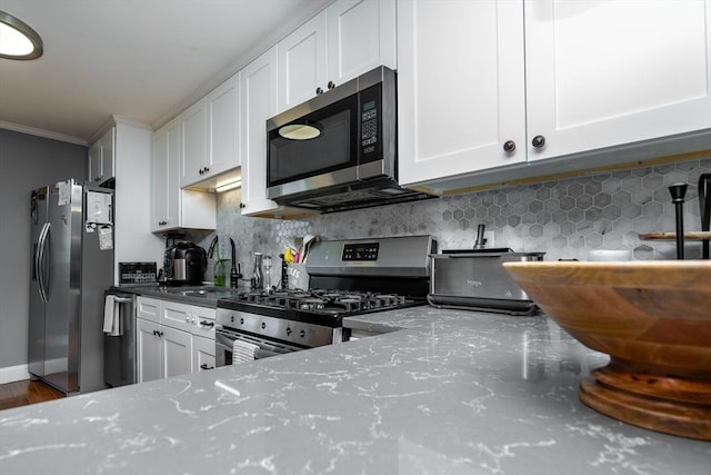 kitchen with white cabinetry, sink, tasteful backsplash, and appliances with stainless steel finishes