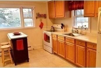 786 Cabot St, Beverly, MA 01915 - kitchen featuring white appliances, light countertops, brown cabinetry, and light tile patterned floors