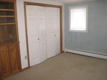 786 Cabot St, Beverly, MA 01915 - unfurnished bedroom featuring a baseboard radiator, a closet, and crown molding