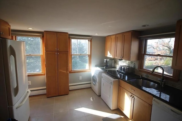786 Cabot St, Beverly, MA 01915 - kitchen with white appliances, a baseboard radiator, brown cabinets, light tile patterned flooring, and washing machine and clothes dryer