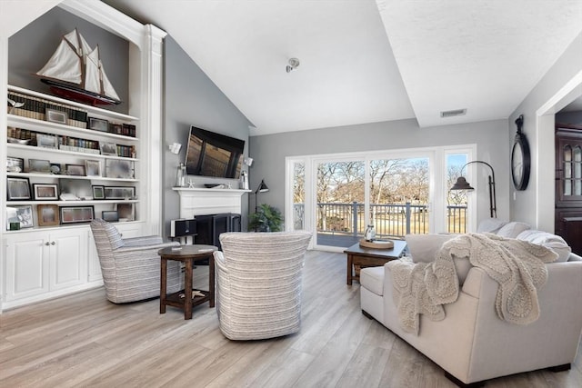 living room featuring high vaulted ceiling and light wood-type flooring