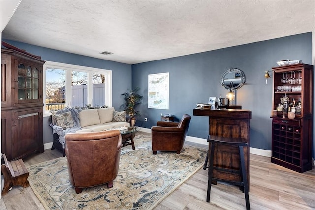 living room featuring light hardwood / wood-style floors and a textured ceiling