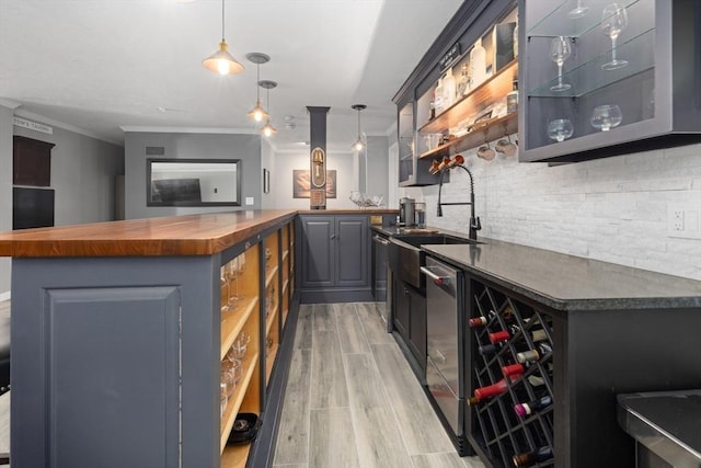 bar featuring sink, wooden counters, light hardwood / wood-style flooring, gray cabinets, and pendant lighting