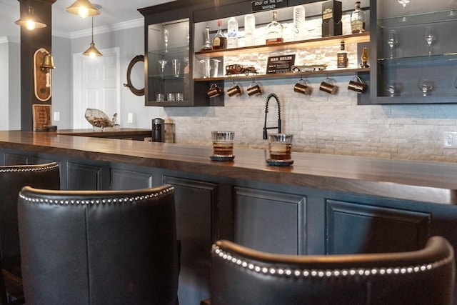 bar with wood counters, hanging light fixtures, tasteful backsplash, and ornamental molding