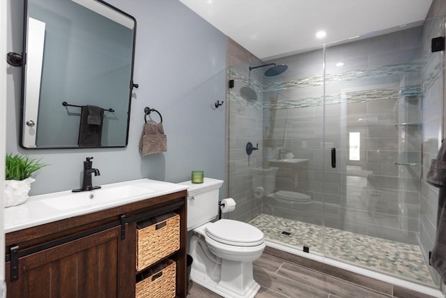 bathroom featuring vanity, an enclosed shower, and toilet