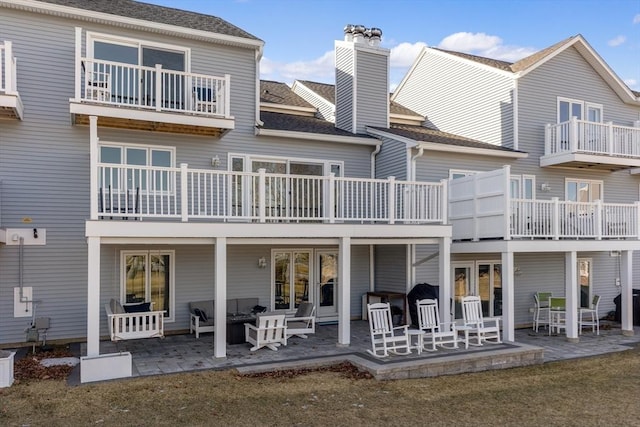 rear view of property featuring a lawn and a patio area