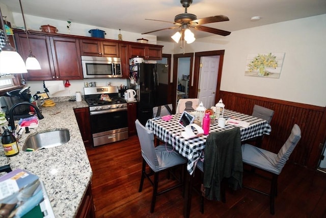 27 Morgan St, Fairhaven, MA 02719 - kitchen with stainless steel appliances, a wainscoted wall, ceiling fan, dark wood-type flooring, and wooden walls