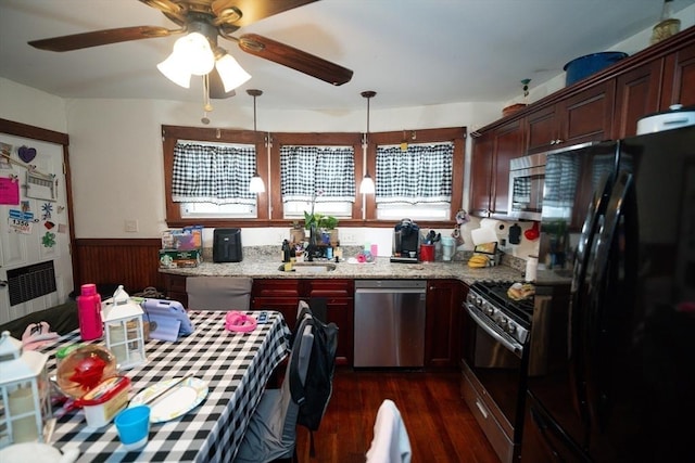 27 Morgan St, Fairhaven, MA 02719 - kitchen with appliances with stainless steel finishes, a wainscoted wall, dark wood-style flooring, a ceiling fan, and light stone countertops