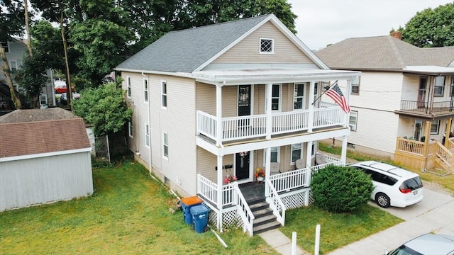 27 Morgan St, Fairhaven, MA 02719 - view of front of house with covered porch, a balcony, a front yard, and a storage shed