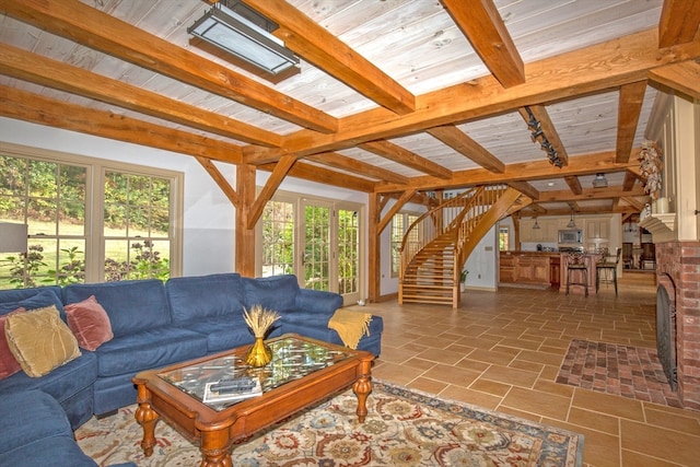 tiled living room featuring a brick fireplace, wooden ceiling, and lofted ceiling with skylight