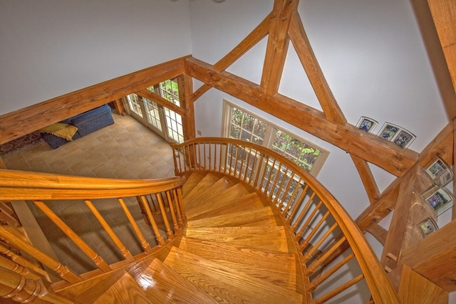 stairway featuring a towering ceiling