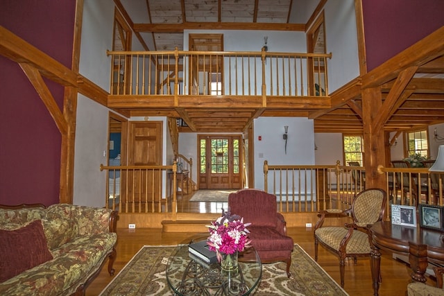 living room with hardwood / wood-style flooring, a high ceiling, and a healthy amount of sunlight