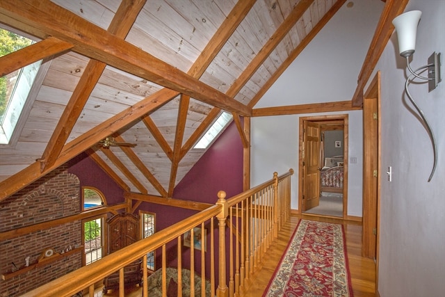 hallway featuring high vaulted ceiling, wood ceiling, beam ceiling, and hardwood / wood-style floors