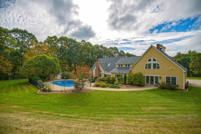 rear view of property featuring a lawn