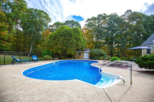 view of swimming pool featuring a patio and an outdoor structure