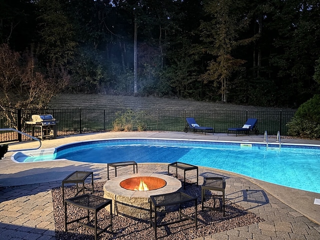 view of swimming pool with a patio area and an outdoor fire pit