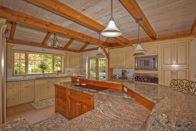 kitchen featuring sink, stainless steel microwave, vaulted ceiling with beams, decorative light fixtures, and black electric cooktop