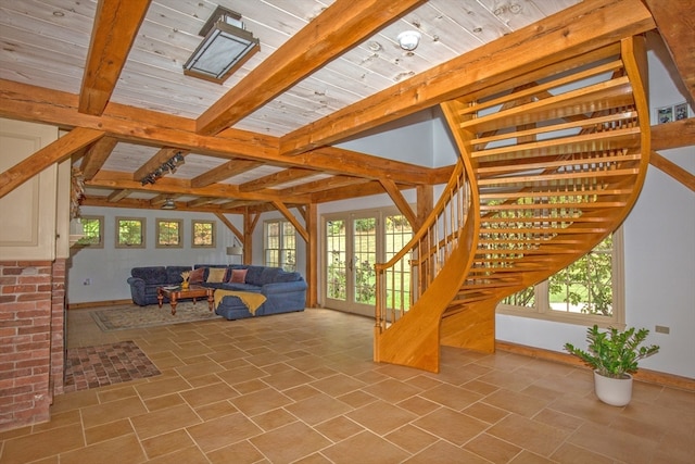 unfurnished living room featuring beam ceiling, wooden ceiling, and a healthy amount of sunlight